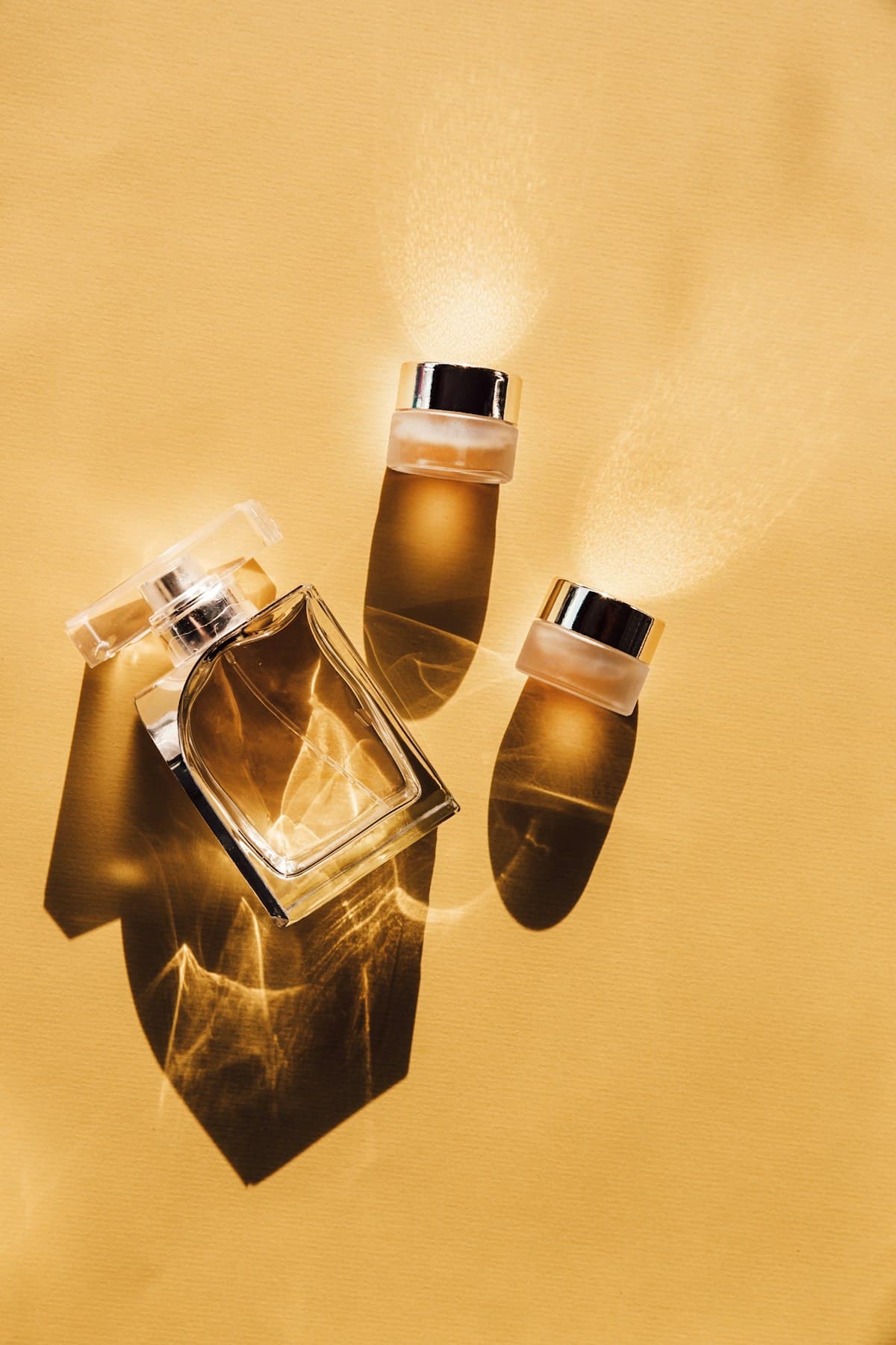 A golden flacon and jars casting warm light on ochre